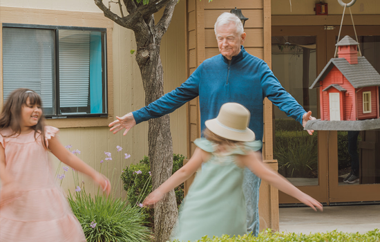 Senior resident plays with grandchildren at Summerfield of Stockton Memory Care in Stockton, CA