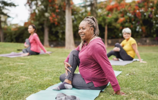 Multiracial elderly women doing yoga exercise in a park.